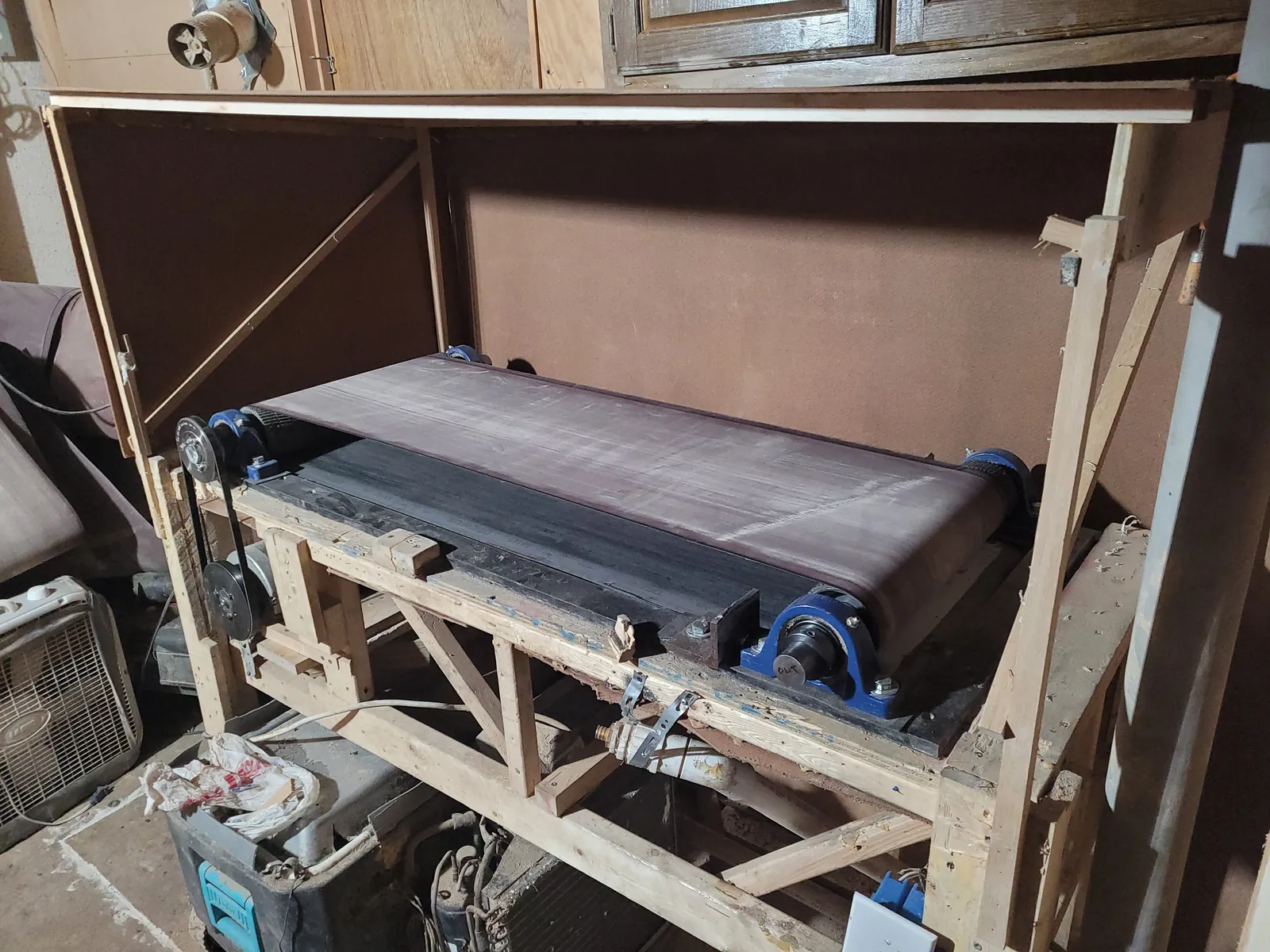 Early version of the water-cooled sanding table built in a wood frame, with the sanding belt on two drum pulleys