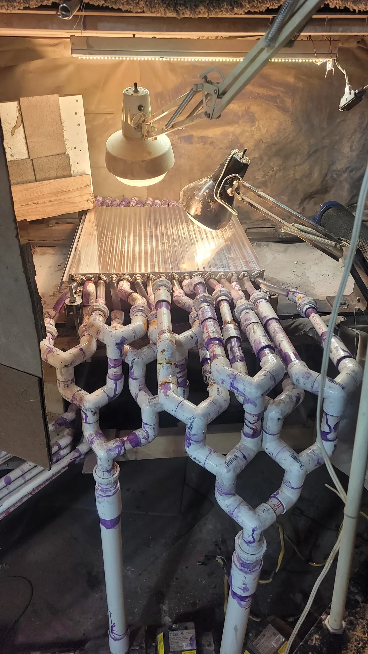 Plumbing under the water-cooled sanding table that feeds water to the 16 passages of the cooling plate